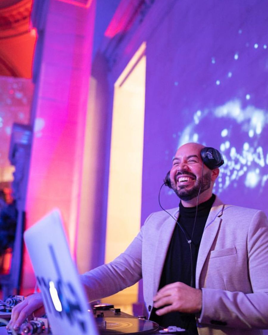 DJ Mode smiling behind his decks at an event