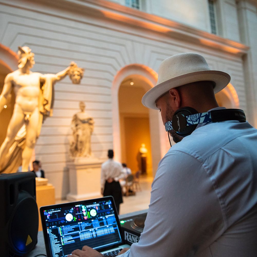 DJ Mode DJing in a museum gallery with classical sculptures